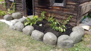 Concrete boulders in front of log building